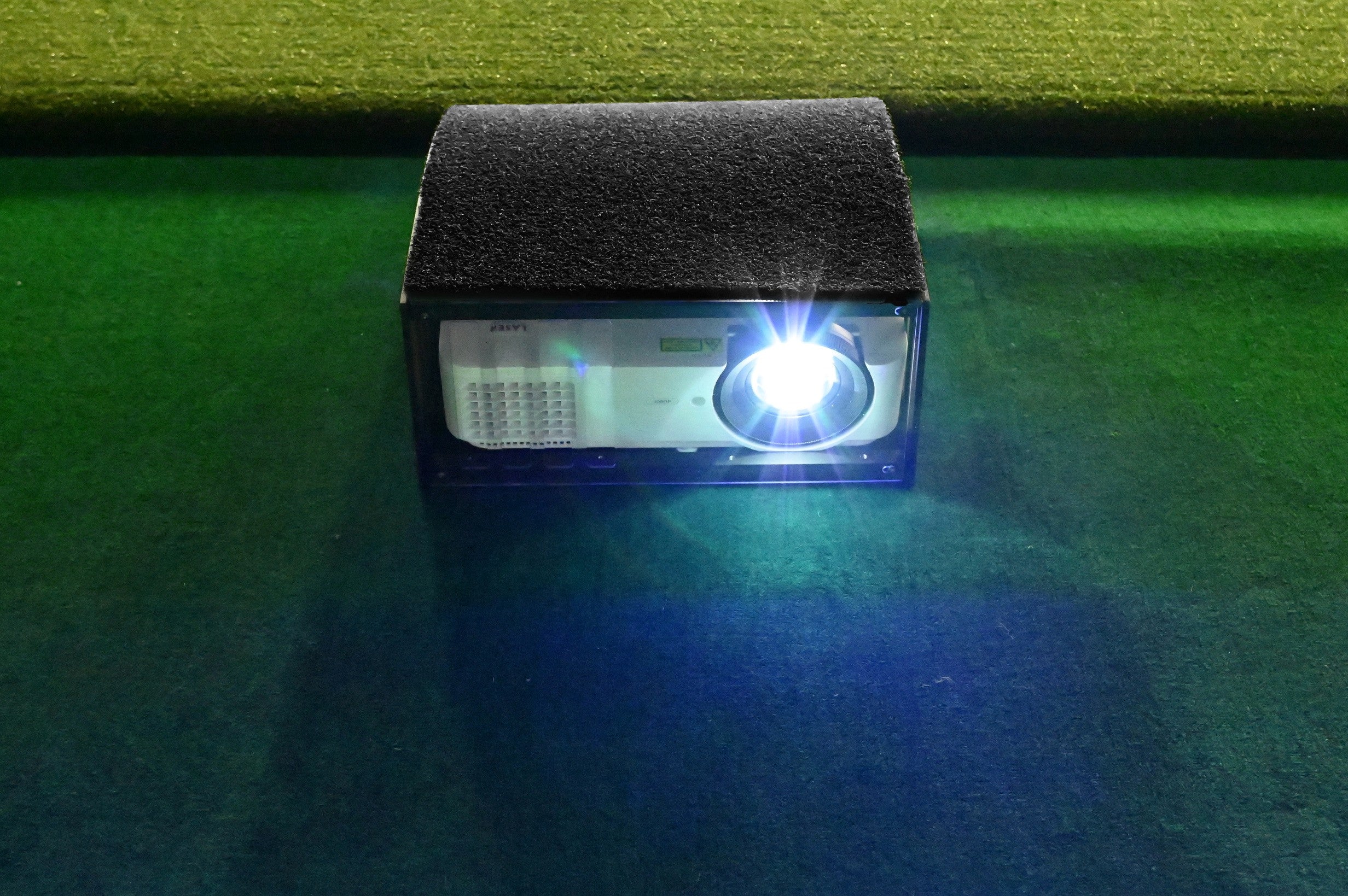 Small projector on a green surface