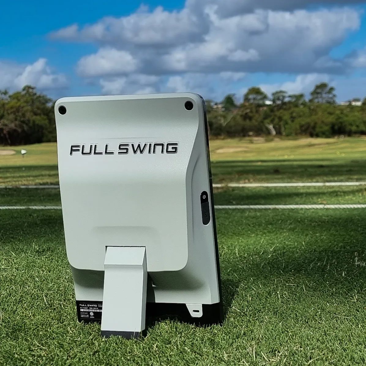 Golf practice device with 'Full Swing' branding on a grassy field