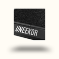 Black rectangular object with textured surface and 'UNEEEKOR' branding on a white background