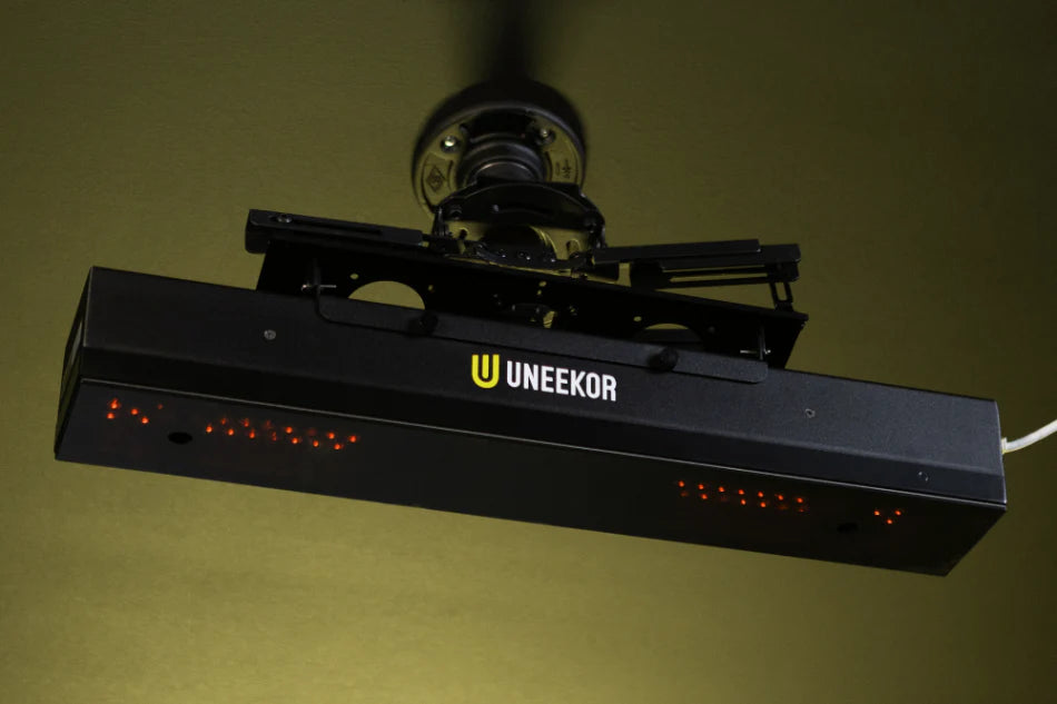 Ceiling-mounted projector with UNEEKOR branding on a yellow background