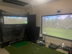 Golf simulator setup with two screens displaying a golf course.