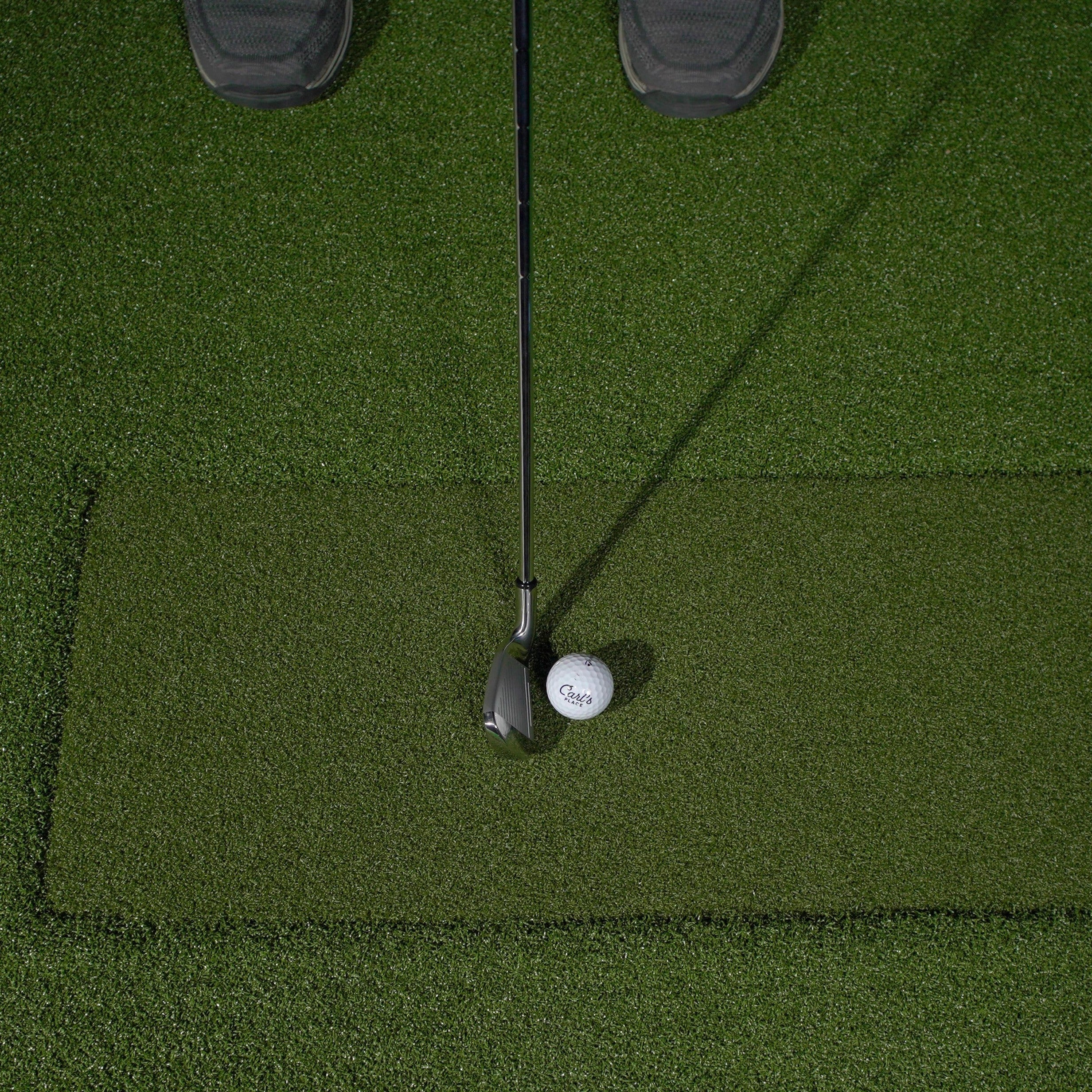 Golf club and ball on a green putting surface