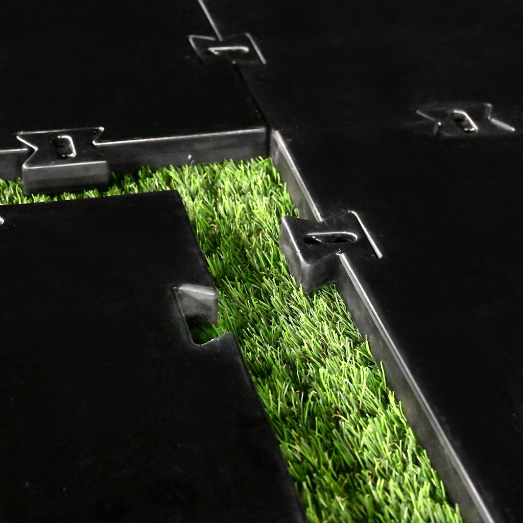 Black interlocking mats on artificial grass