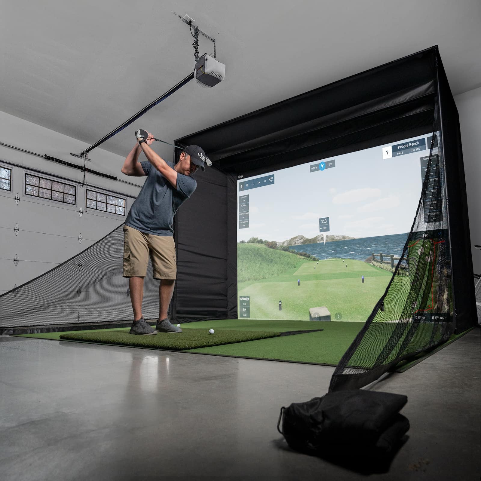Person using a golf simulator in a home garage