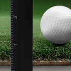 Golf ball on grass with a ruler for scale